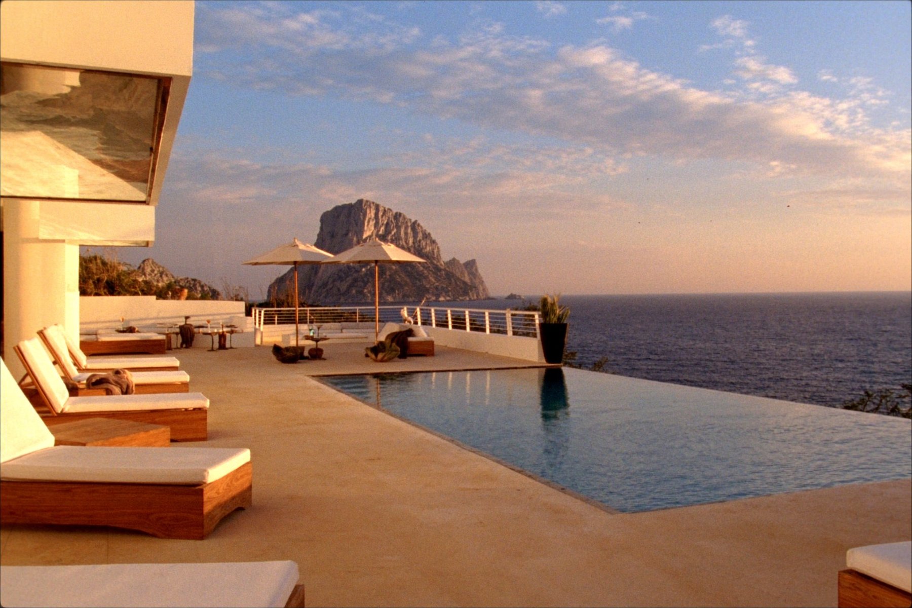 Villa terrace with infinity pool facing Es Vedrà at sunset, Ibiza